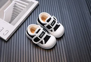 Detail view of black fleece-lined toddler canvas shoes with velcro strap and white rubber sole
