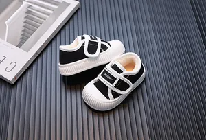 Close-up of black and white children's canvas shoes with warm fleece lining and velcro strap