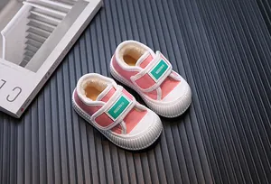 Detailed macro view of pink kids canvas shoes with warm fleece lining and green velcro strap