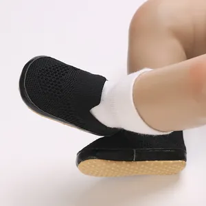 Vista dettagliata delle scarpine da neonato in maglia nera con suola antiscivolo