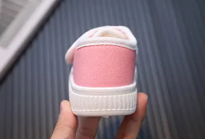Detailed view of the heel and textured white sole on these pink canvas children shoes