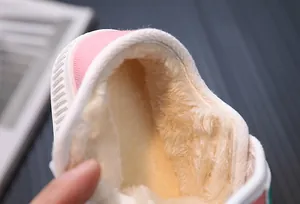 Close-up of soft warm faux fur lining inside pink children's canvas sneakers
