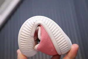 Close-up showing the flexible white sole of a pink toddler canvas shoe