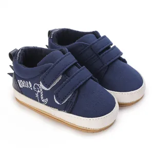 Details von marineblauen Baby-Lauflernschuhen aus Segeltuch mit Dinosaurier