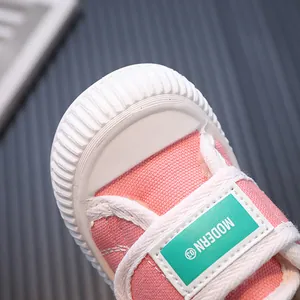 Macro view of pink toddler canvas shoes featuring white rubber sole and MODERN label