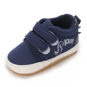 Detailansicht dunkelblauer Babyschuhe aus Canvas mit Dinosaurier-Stickerei und Klett.