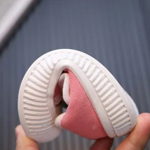 Close-up of flexible rubber sole on pink canvas toddler shoes with soft bendable design