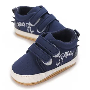 Detail von dunkelblauen Babyschuhen mit süßem Dinosaurier- und Brüllstickerei-Design