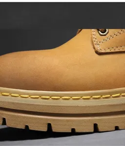 Close-up of yellow work boot detail showing premium suede texture and stitching