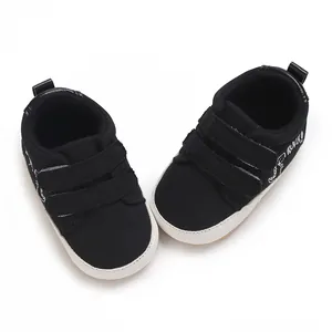 Nahaufnahme schwarzer Baby-Lauflernschuhe aus Segeltuch mit praktischem Klettverschluss