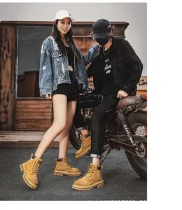 Couple wearing stylish yellow outdoor Martin boots by a motorcycle in a street setting