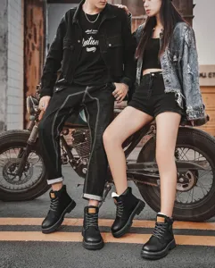 Durable black British style Martin boots for couples shown in an urban street scene