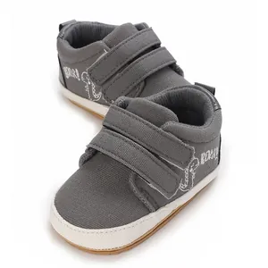 Rutschfeste graue Baby-Lauflernschuhe aus Segeltuch mit süßem Stick-Dinosaurier-Motiv.