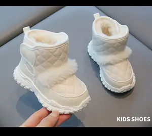 Close-up detail of white quilted kids' snow boots featuring warm plush lining and fur trim.
