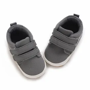 Draufsicht auf graue Baby-Lauflernschuhe mit doppeltem Klettverschluss und weißer Sohle