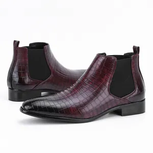 Detailopname van bordeauxrode Chelsea boots voor heren met krokodillenstructuur en vierkante neus.
