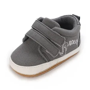 Detailansicht grauer Canvas-Lauflernschuhe für Babys mit süßer Dinosaurier-Stickerei