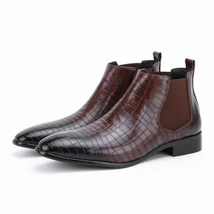 Zijaanzicht detail van bruine Chelsea boots met krokodillenpatroon en een neus.