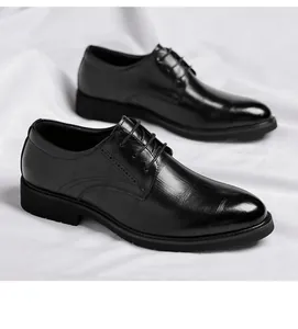 Detail shot of black textured leather derby shoes with brogue accents on white fabric.