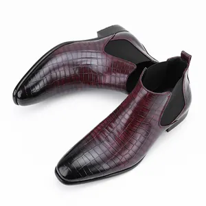 Detail van bordeauxrode Chelsea-boots voor heren met krokodillenreliëf en vierkante teen.