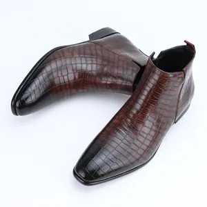 Detailaufnahme der braunen Krokodilleder-Struktur auf modischen Chelsea-Boots für Herren