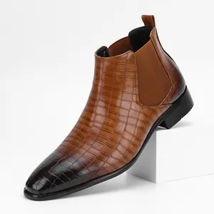 Detail van bruine Chelsea boot met krokodillentextuur, vierkante neus en elastiek.