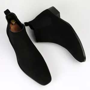 Macro shot of stylish men's black suede Chelsea boots featuring a small square toe design.