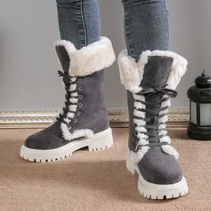Detailed view of grey winter snow boots with white fur lining and thick platform soles.