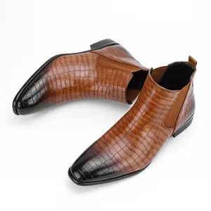 Close-up view of men's Chelsea boots featuring brown crocodile embossed leather texture