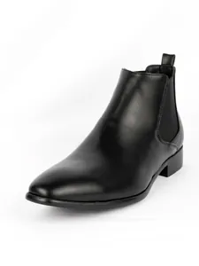 Detailed view of a black leather Chelsea boot with a small square toe design