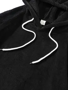 Gedetailleerde weergave van zwarte koraalfleece hoodie met details van het wasetiket
