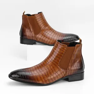 Detailed macro view of brown crocodile embossed men's Chelsea boots on white base
