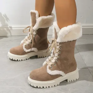 Close-up of brown suede snow boots with white faux fur trim and lace-up details