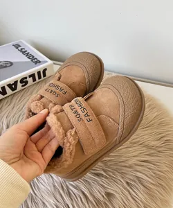 Close-up of children's winter cotton shoes showing warm fleece lining and suede texture.