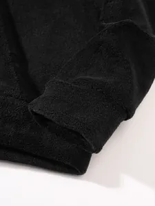 Close-up van de zachte zwarte koraalvliesstoftextuur op een mouw van een herenhoodie