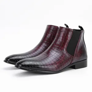 Close-up detail of men's burgundy and black crocodile-embossed leather Chelsea boots