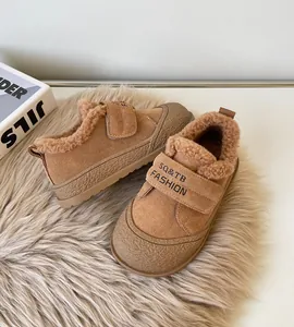 Close-up of brown children's winter boots with cozy fleece lining and velcro straps.