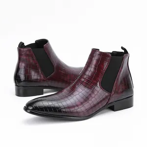 Macro detail showing burgundy crocodile-embossed leather texture on men's Chelsea boots