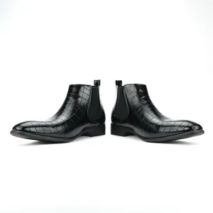 Detail of black men's Chelsea boots with textured crocodile pattern and stylish square toe