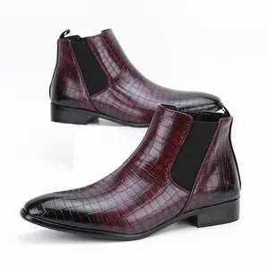 Close-up of burgundy crocodile pattern Chelsea boots with black gradient finish.