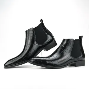 Detailed view of men's black Chelsea boots with crocodile pattern and square toe.