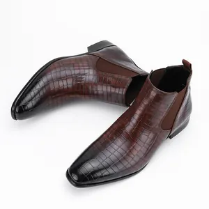 Detailed view of men's brown crocodile texture Chelsea boots with black gradient toes.