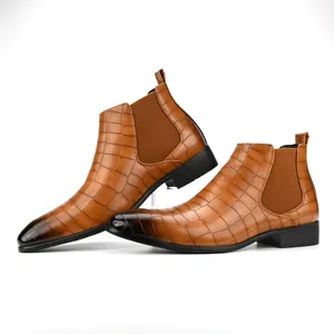 Close-up detail of stylish tan crocodile pattern men's Chelsea boots with square toe