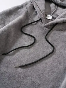 Macro-detail met de zachte textuur van grijze koraalvliesstof op een herenhoodie met capuchon
