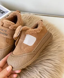 Close-up of warm brown children's winter shoes with thick faux fur lining and velcro strap