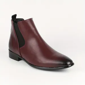 Detail showing smooth leather finish and elastic side panel of a burgundy Chelsea boot