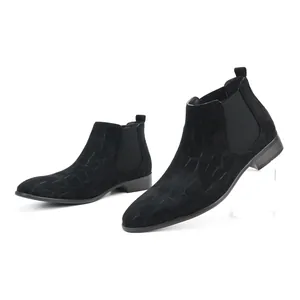 Detailed macro view of men's black suede Chelsea boots with crocodile texture.