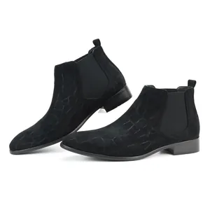 Detail shot of men's black Chelsea boots with embossed crocodile texture and square toe.