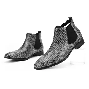 Close-up detail of stylish men's metallic silver Chelsea boots with scale pattern.