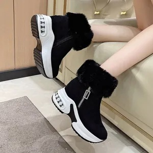 Stilvolle schwarze Kunstfell-Schneestiefel mit dicker weißer Plateausohle für den Winter